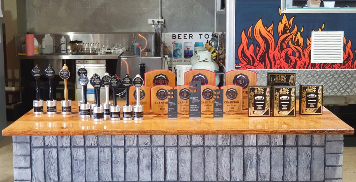 At their Production House taproom on Caloundra Road, there’s an entire bench dedicated to housing MBBCo's trophies... and it’s getting crowded.